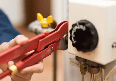 Plumber repairing hot water system valve to restore supply and stop leaks