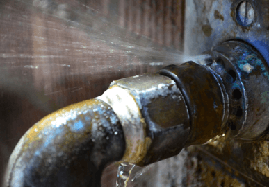 Burst pipe leaking at joint, plumber repairs fast to prevent water damage