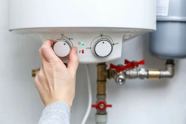 Plumber Calibrating the electric heater