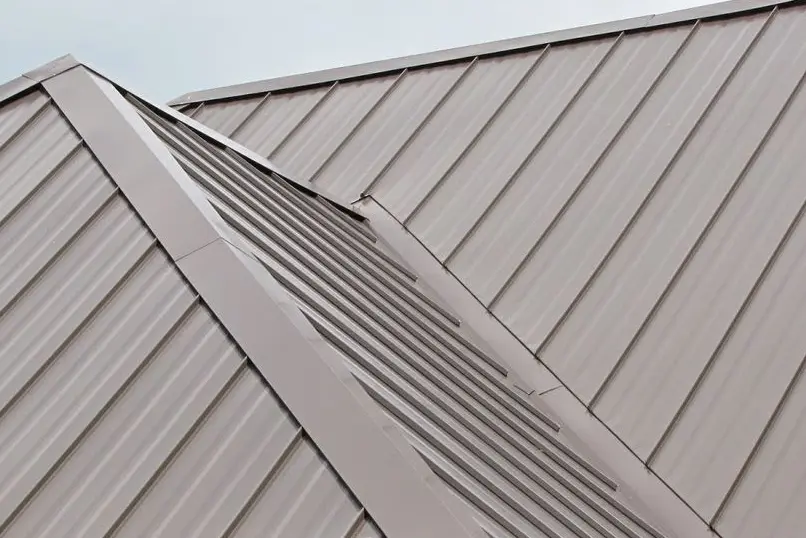 Metal roof with flashing installed along ridge for weatherproofing
