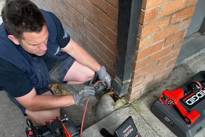 A plumber using a specialised equipment to clear a blocked drain
